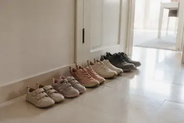 Bir evin girişinde, kapının yanında yan yana dizilmiş yetişkin ve çocuk ayakkabıları